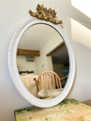 White oval mirror with gold bow
